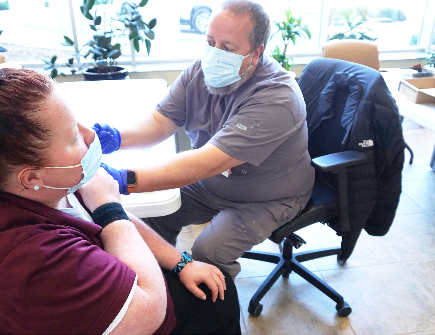 Melanie Jacobson with environmental services gets a vaccine from head pharmacist Casey White. The vaccine clinic hours will be changing beginning March 10.